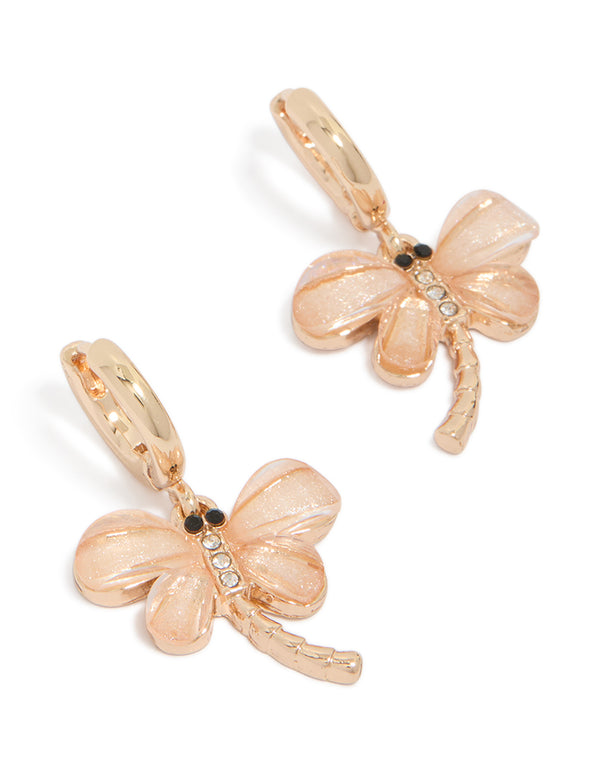Showcasing pink dragonfly gold huggie hoop earrings with animal charm, wings, and glitter accents front view