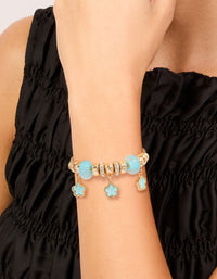 Featuring a beaded charm bracelet with floral details in gold and light blue on wrist view - link has visual effect only