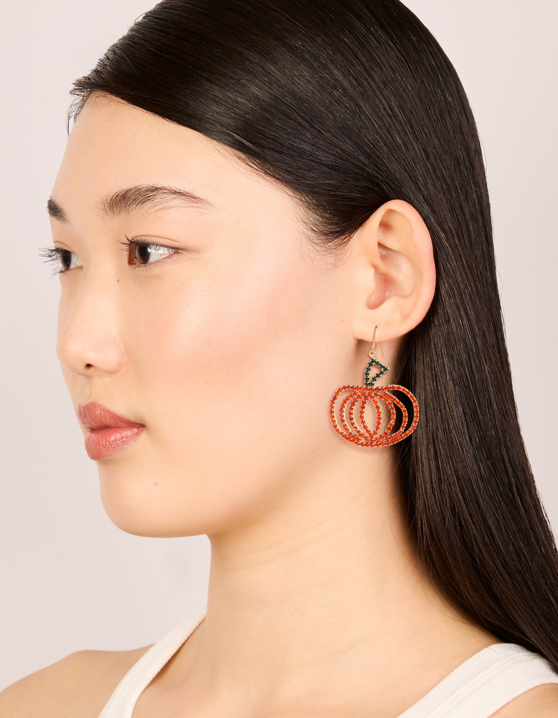 Styled chunky gold glam pumpkin drop earrings featuring food design in orange, dark green on model view