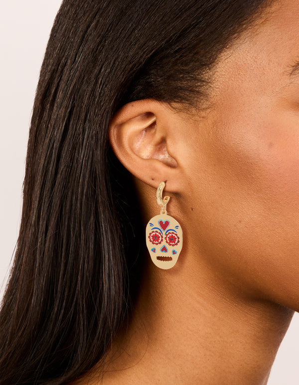 Shop these gold fun skull drop earrings with floral and heart accents on ear view