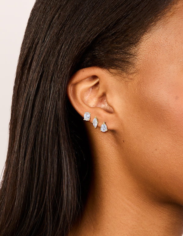 Featuring waterproof gold plated stainless steel cubic zirconia classic stud earrings in a 3-pack with round, marquise, and pear stone cuts on ear view
