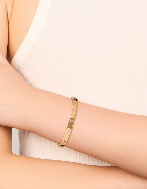 Elegant waterproof gold plated stainless steel hinged bracelet with pink diamante detailing on wrist view