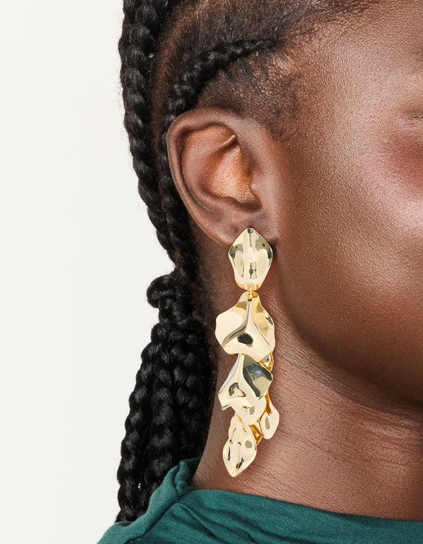 Showcasing statement multi petal drop earrings in gold plated finish on ear view
