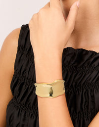 Showcasing a statement wavy wrist cuff crafted from plated metal in gold bangle on wrist view - link has visual effect only