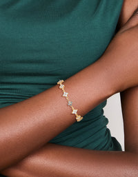 This flower bracelet crafted from gold plated metal with cubic zirconia in beige and clear, statement style on wrist view - link has visual effect only