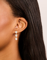 Featuring gold plated cubic zirconia trio oval drop earrings on ear view - link has visual effect only